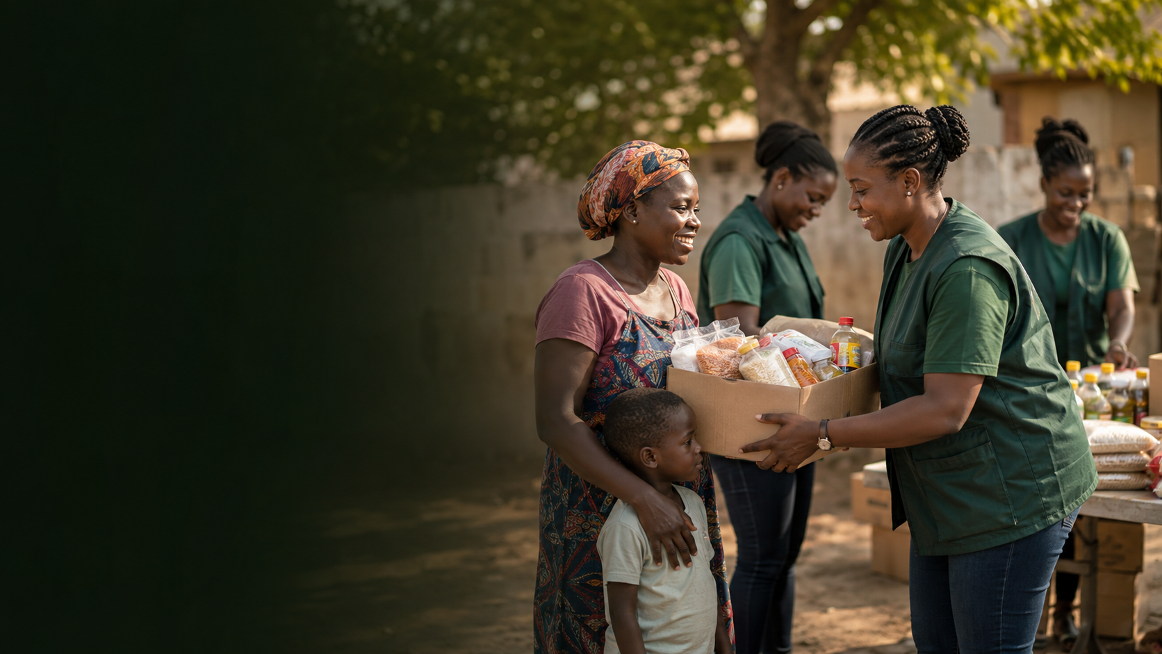 A foundation volunteer providing food and essential supplies to a mother and child during a community relief program.